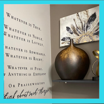 A framed calligraphy print displayed beside a dark bronze vase